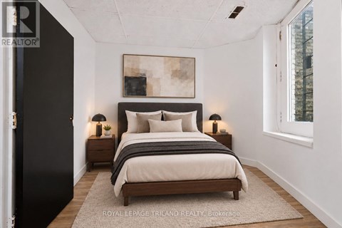 A bedroom with a large bed and two nightstands.