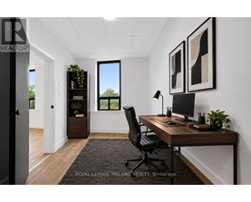 A well-lit office space with a desk, chair, and two framed pictures on the wall.