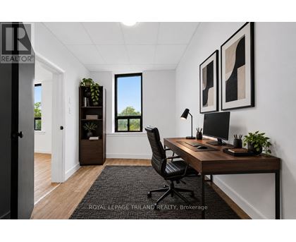 A well-lit office space with a desk, chair, and two framed pictures on the wall.