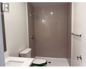 A bathroom with a toilet, sink, and shower.