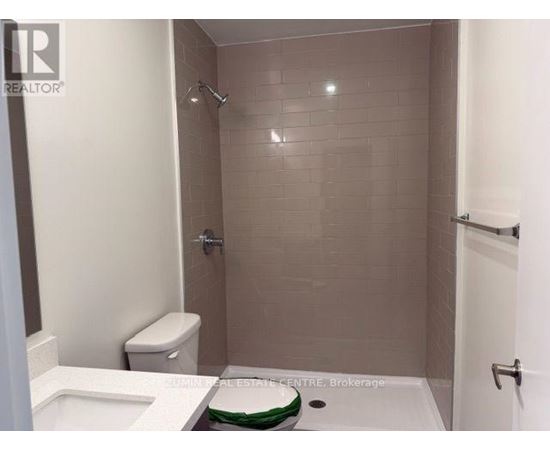 A bathroom with a toilet, sink, and shower.