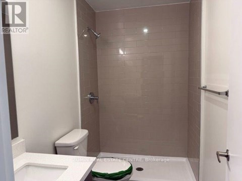 A bathroom with a toilet, sink, and shower.