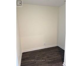 A room with white walls and dark wood flooring.