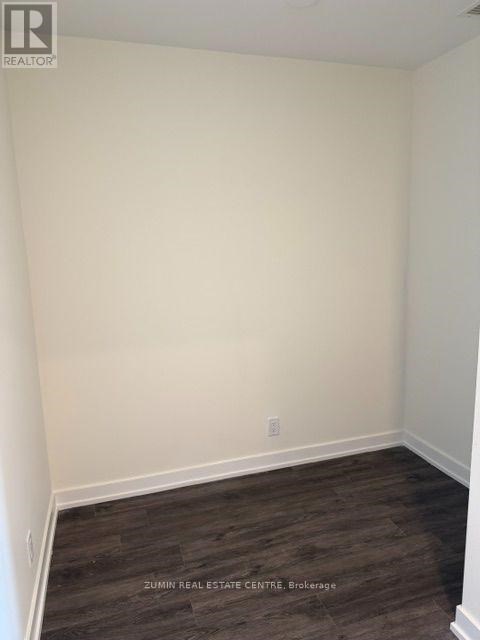 A room with white walls and dark wood flooring.