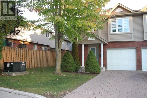 A house with a garage and a tree in front.