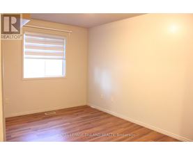 A room with a window and wooden flooring.
