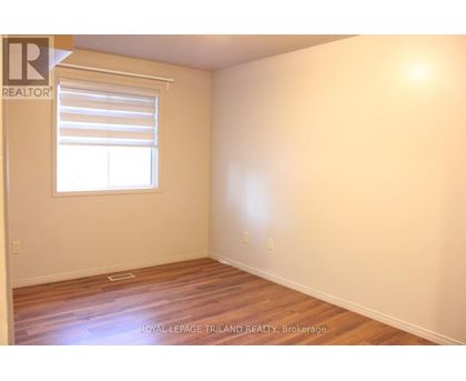 A room with a window and wooden flooring.