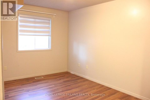 A room with a window and wooden flooring.