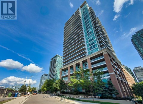A tall building with many windows is the focal point of the image.