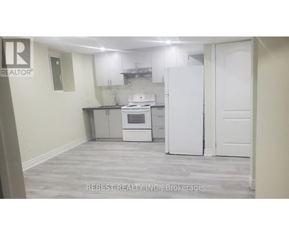 A kitchen with a white fridge and oven, and a white door.