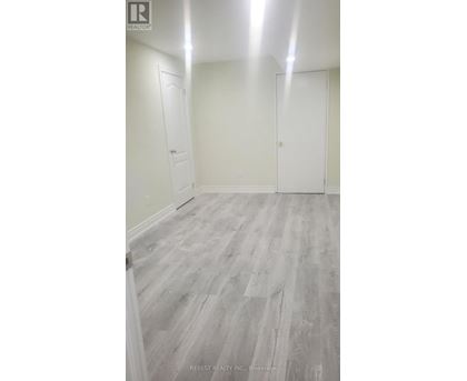 A room with wood flooring and white walls.