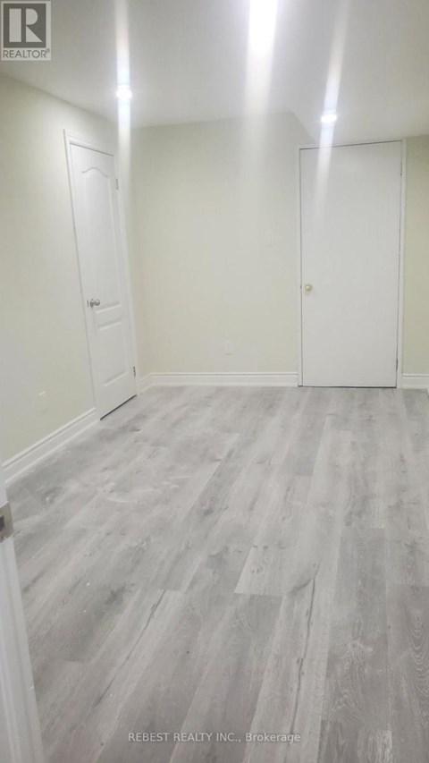 A room with wood flooring and white walls.