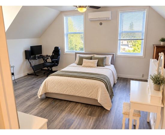 A bedroom with a bed, desk, and chair.