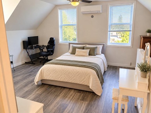 A bedroom with a bed, desk, and chair.