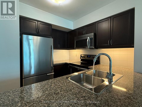 A kitchen with a sink and a refrigerator.