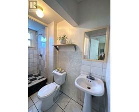 A white toilet and sink in a bathroom.