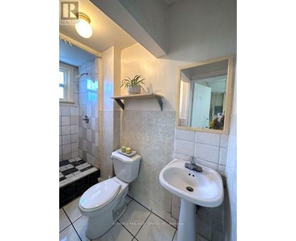 A white toilet and sink in a bathroom.