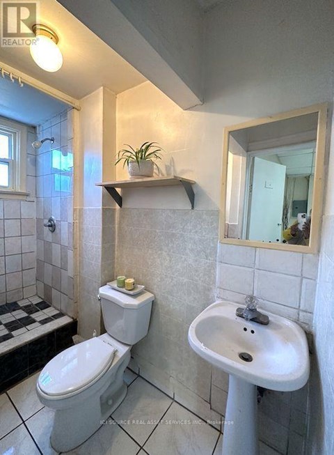 A white toilet and sink in a bathroom.