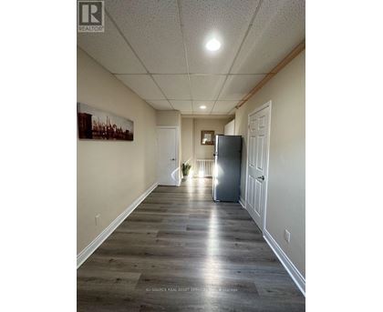 A long hallway with a refrigerator in the middle.