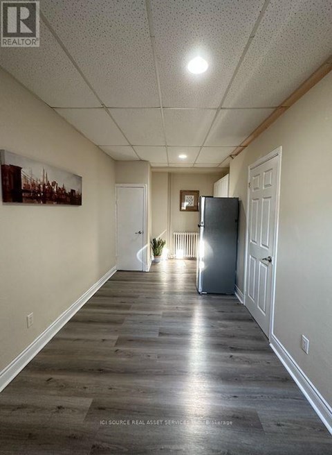 A long hallway with a refrigerator in the middle.