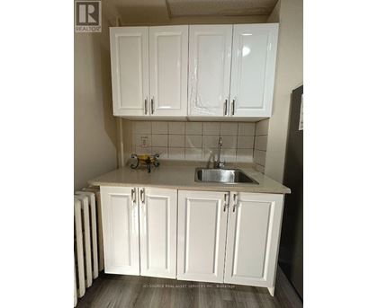 A kitchen with white cabinets and a sink.