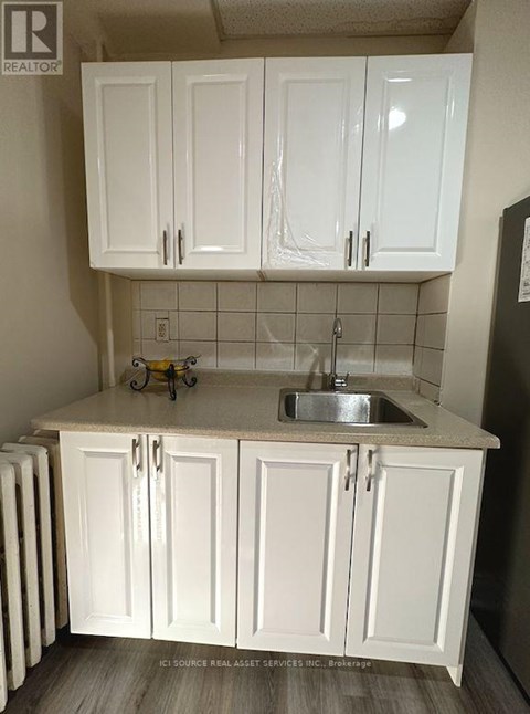 A kitchen with white cabinets and a sink.