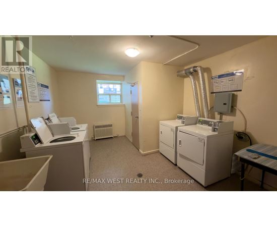 A room with a washing machine, dryer, and a window.