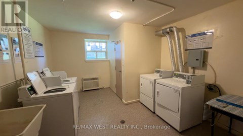 A room with a washing machine, dryer, and a window.