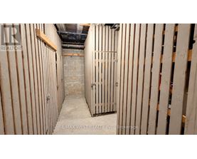 A long, narrow, unfinished room with wooden studs on the walls.
