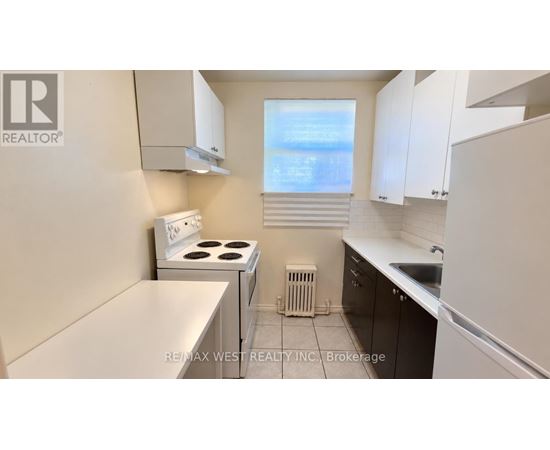 A small kitchen with a stove top oven and a refrigerator.