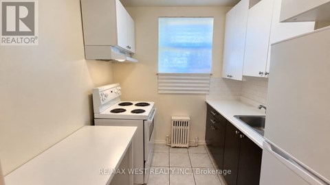 A small kitchen with a stove top oven and a refrigerator.
