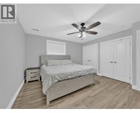A bedroom with a bed, nightstand, and a ceiling fan.