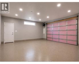 A spacious garage with a pink rolling shutter door.