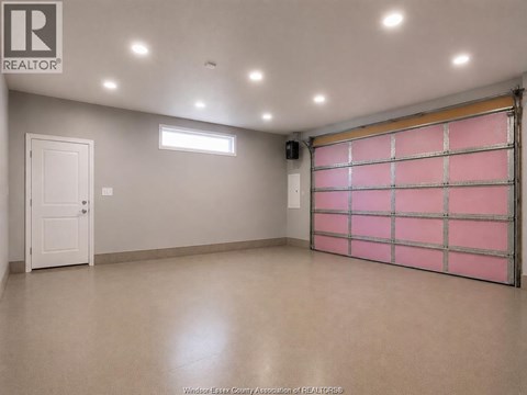 A spacious garage with a pink rolling shutter door.