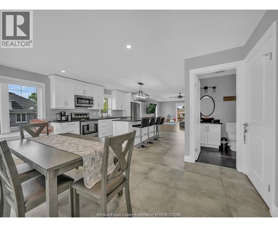 A kitchen with a table and chairs in front of it.