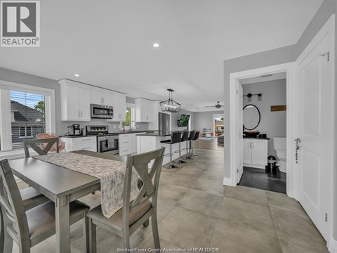 A kitchen with a table and chairs in front of it.