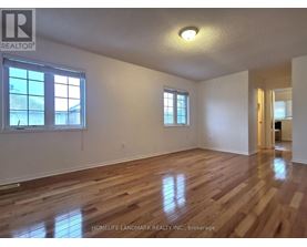 A room with wooden floors and two windows.