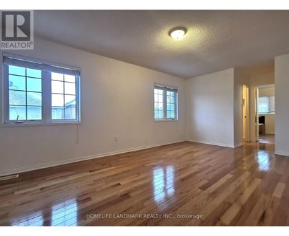A room with wooden floors and two windows.