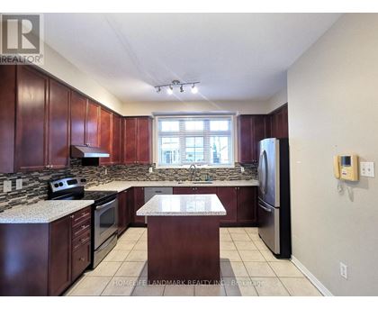 A kitchen with dark wood cabinets and granite countertops.