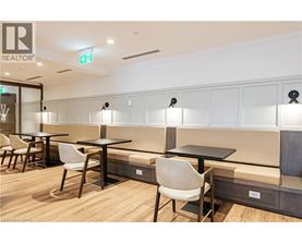 A modern dining area with wooden floors and white chairs.