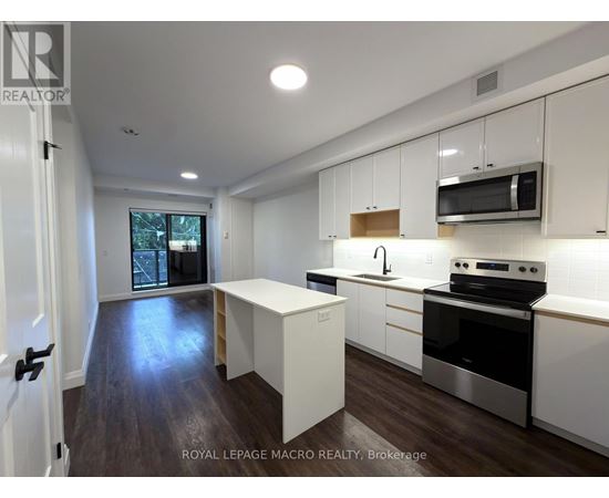 A modern kitchen with white cabinets and stainless steel appliances.