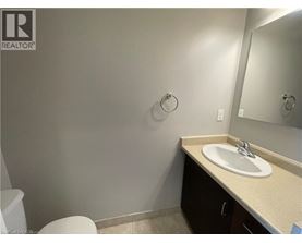 A bathroom with a toilet, sink, and mirror.