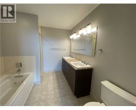 A bathroom with a tub, sink, and mirror.