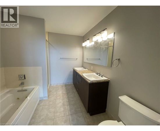 A bathroom with a tub, sink, and mirror.