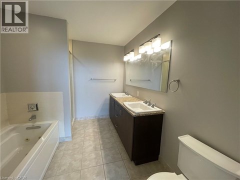 A bathroom with a tub, sink, and mirror.