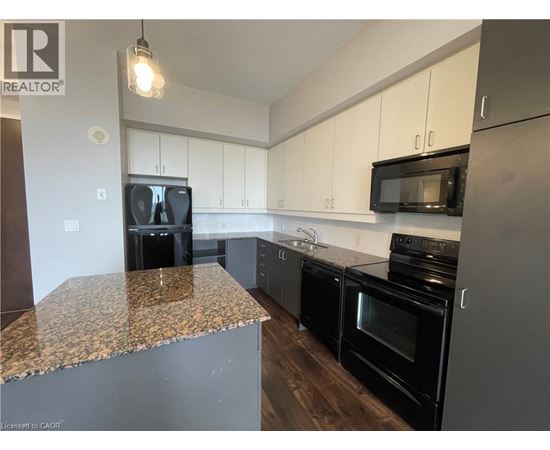 A kitchen with black appliances and a granite countertop.