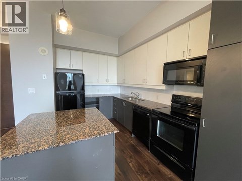 A kitchen with black appliances and a granite countertop.