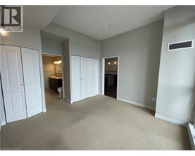 A spacious room with a carpeted floor and white walls.