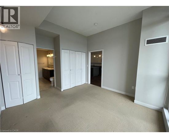 A spacious room with a carpeted floor and white walls.