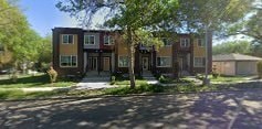 A row of townhouses with trees in front.